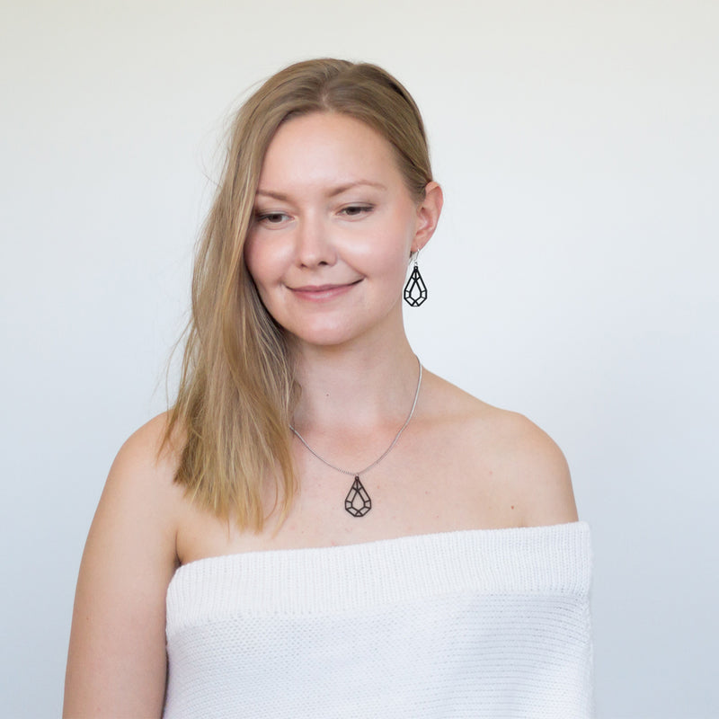 Woman in white top wearing Valona Drop Birch jewelry