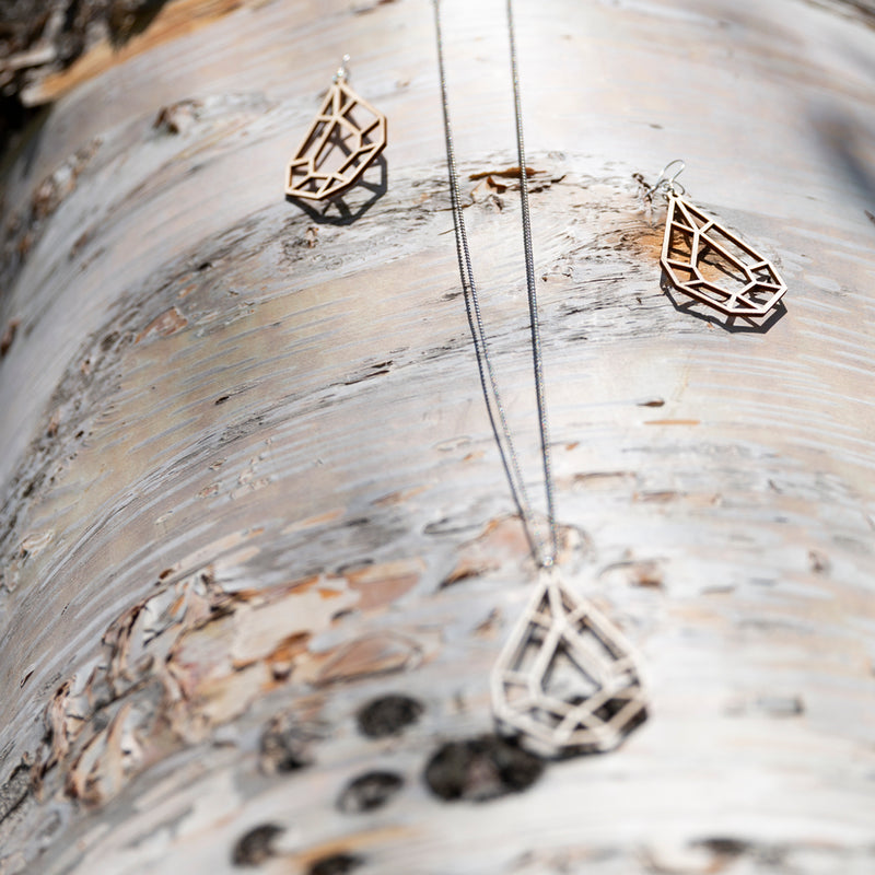 Valona Drop Birch jewelry on birch log